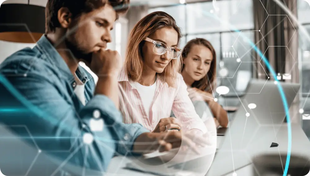 3 people looking at a laptop, presumably Cloud Computing